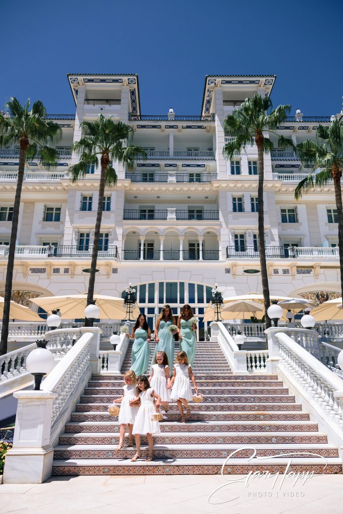 Bridesmaids and flower girls coming down the stairs at the Gran Hotel Miramar wedding venue