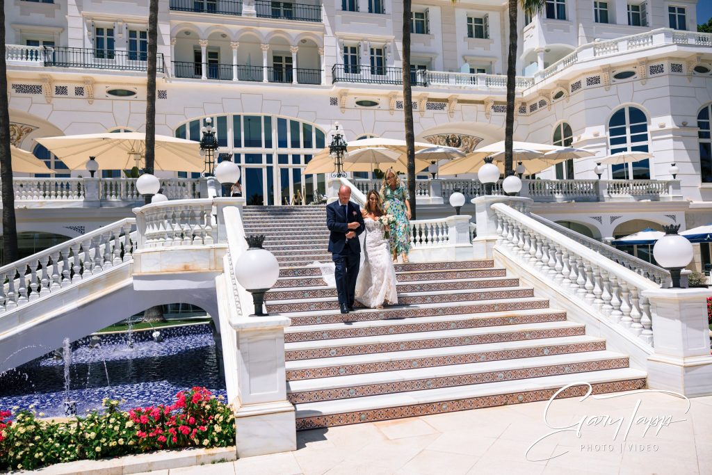 Father of the bride and bride coming down the stairs at the Gran Hotel Miramar wedding venue