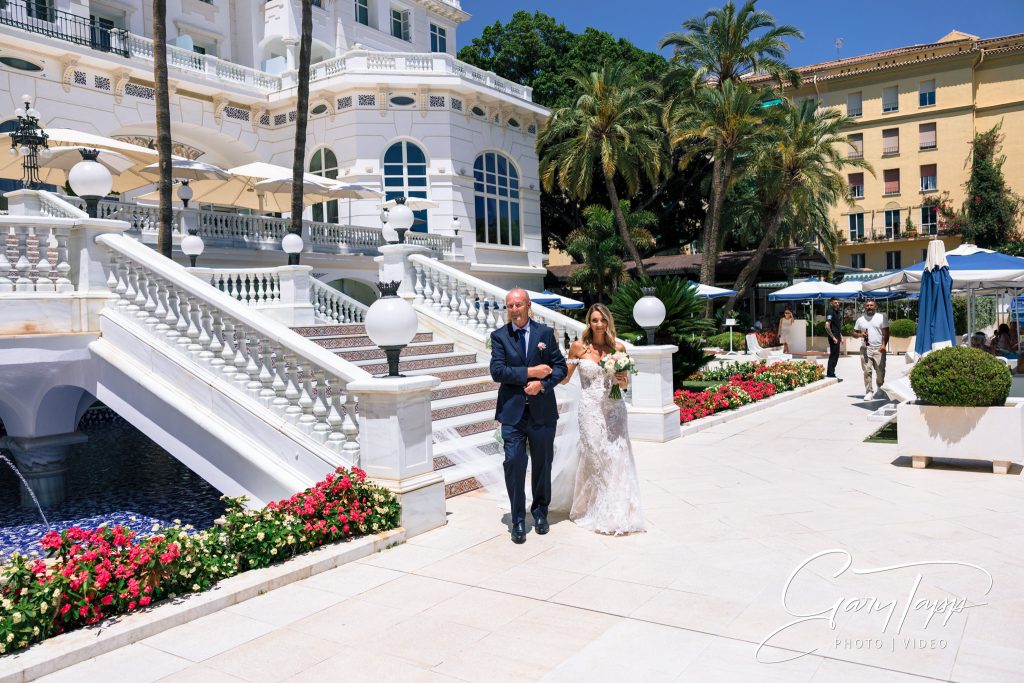Father of the bride and bride coming down the stairs at the Gran Hotel Miramar wedding venue